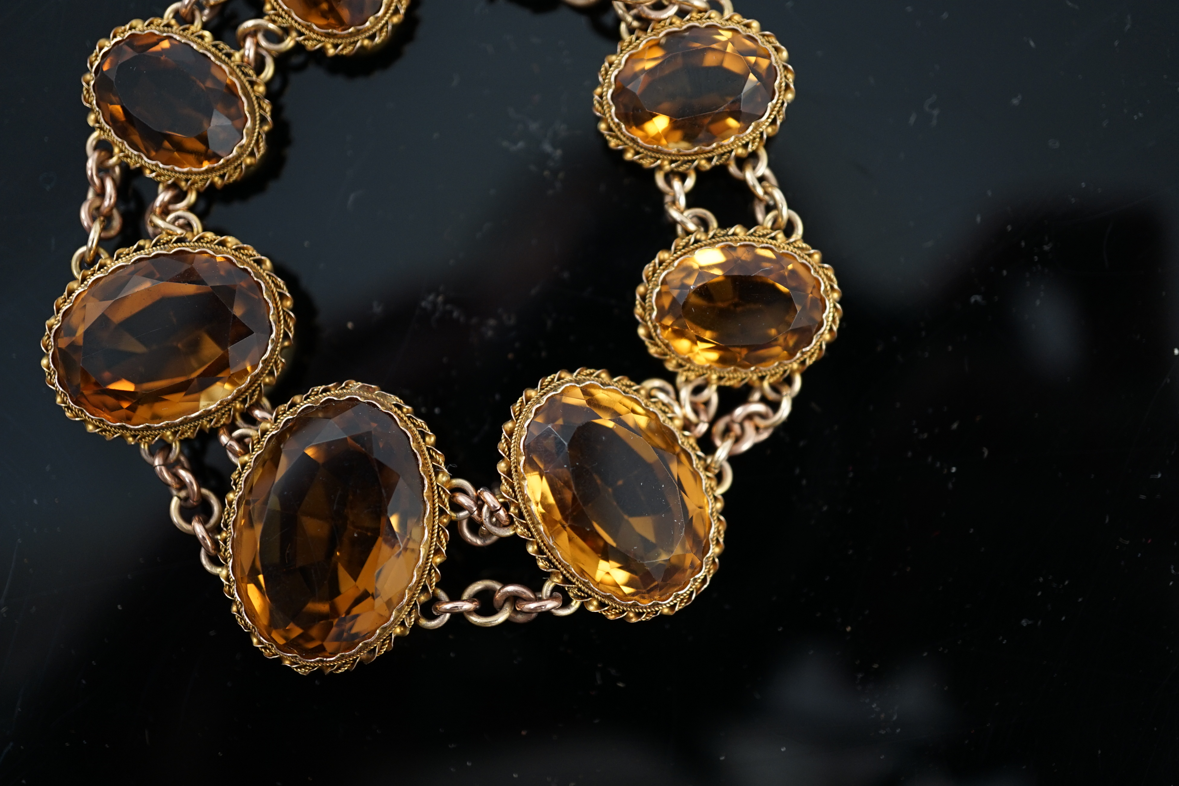 An early 20th century 9ct gold and graduated seven stone oval cut citrine set bracelet